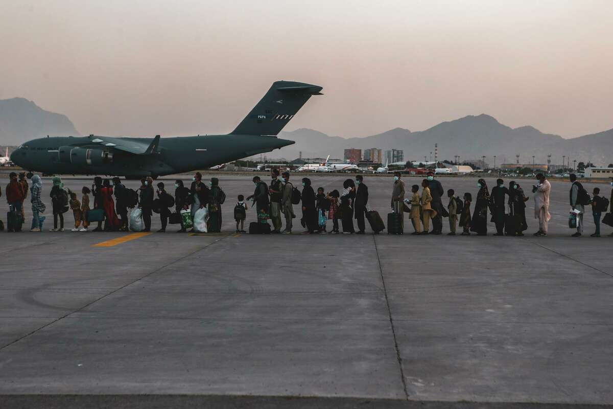 Evacuees wait to board a Boeing C-17 Globemaster III at Hamid Karzai International Airport in Kabul, Afghanistan, last week. What ghosts travel with them?