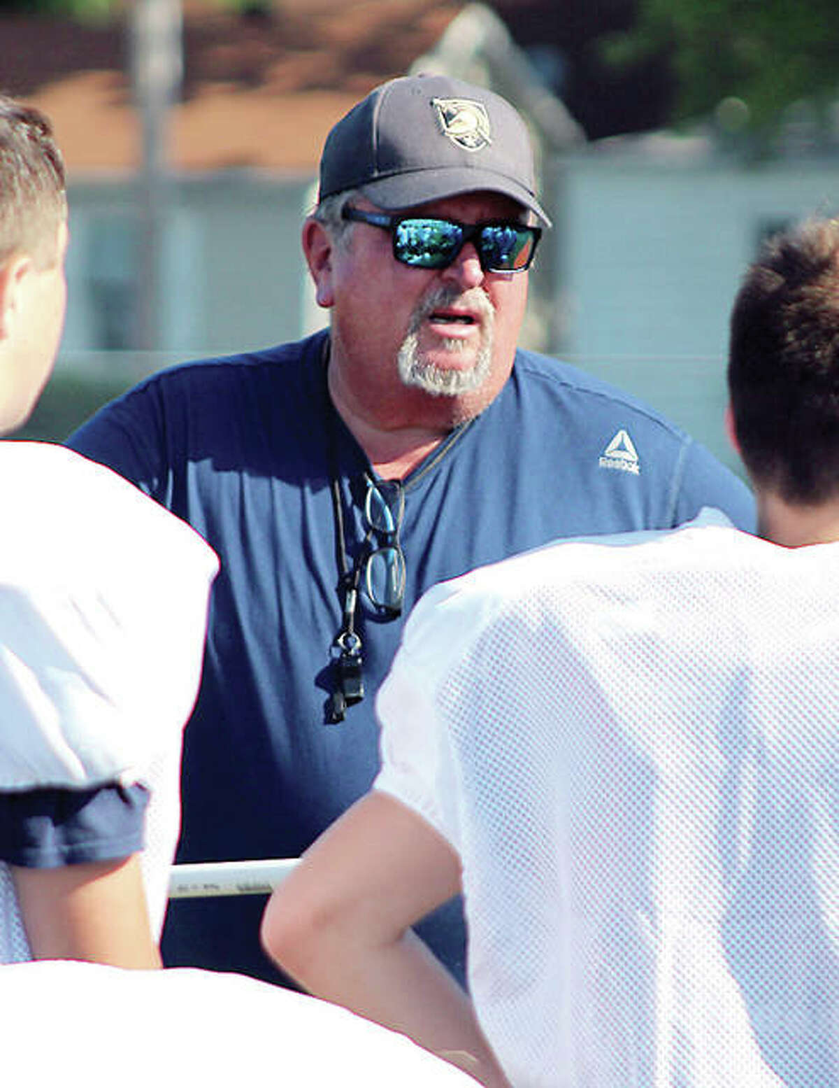 Jersey football coach Ric Johns speaks with his players during a practice session.