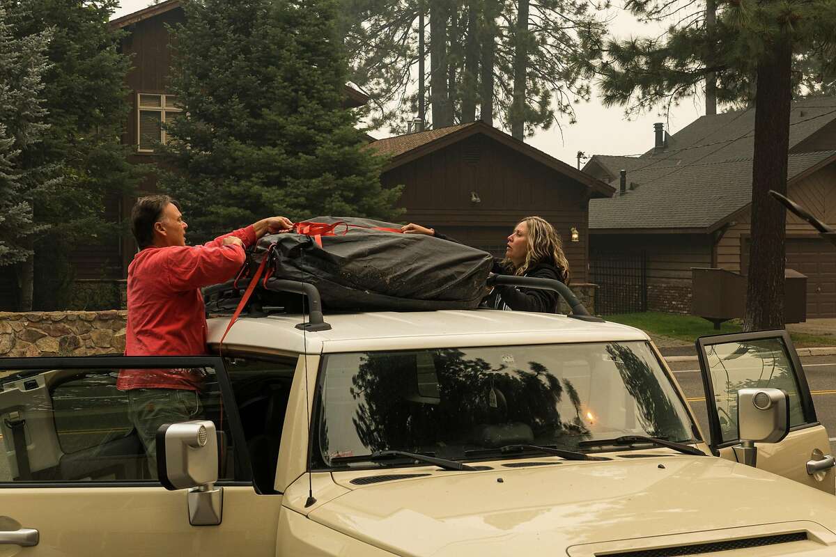 Don Boatwright helps his friend RaShell Holland pack her FJ Cruiser in South Lake Tahoe. Holland is leaving town with her 17-year-old son to escape the wildfire smoke. She has lived in the area since 1995 and says this is the worst air quality she has experienced. She said the air quality in her bedroom last night reached 555.