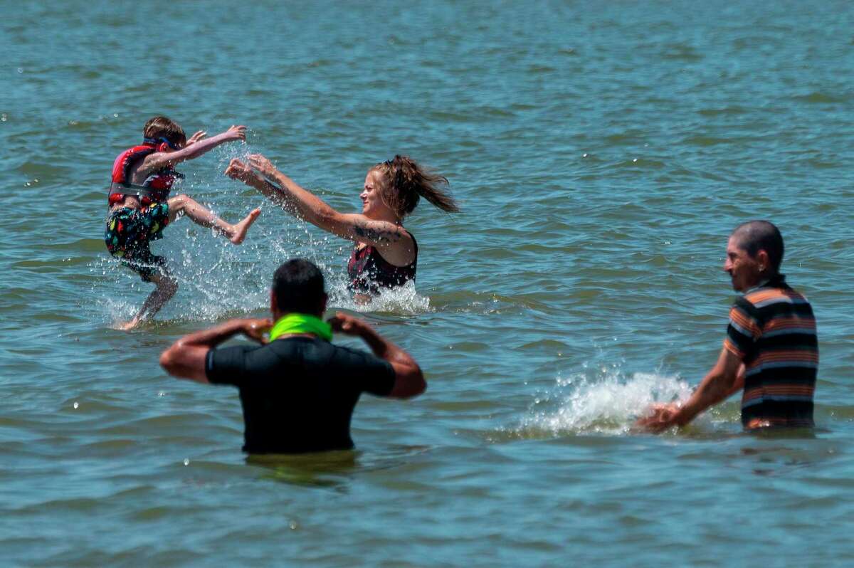 People try to escape the heat in the Chesapeake Bay at Sandy Point State Park in Annapolis, Maryland. Heat indices in Big Rapids this weekend could reach the high 90s. (Photo by JIM WATSON/AFP via Getty Images)