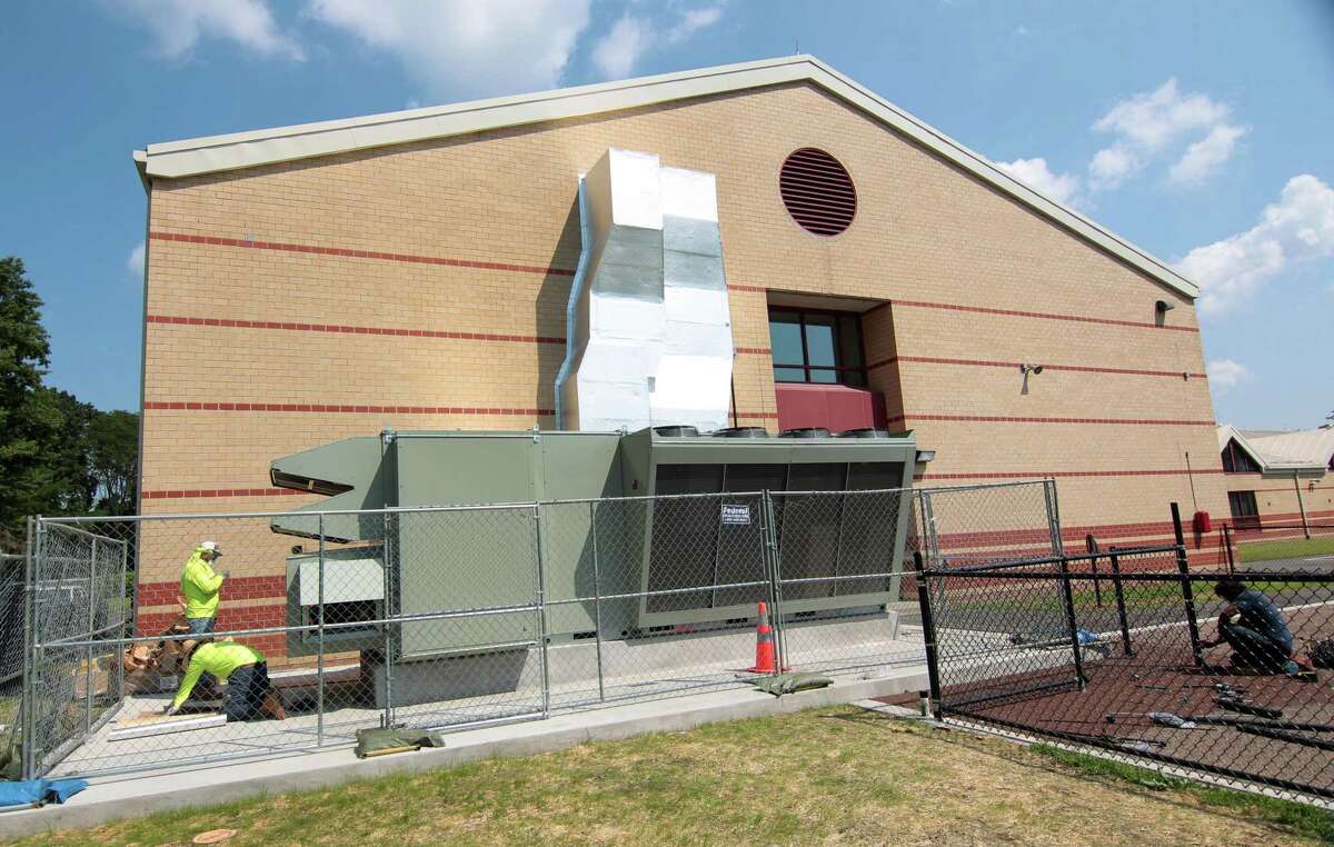 Workers from KMK Insulation of North Haven, finish working on the new DOAS system, or "dedicated outdoor air system," at Westover Elementary School in Stamford, Conn., on Friday August 27, 2021.