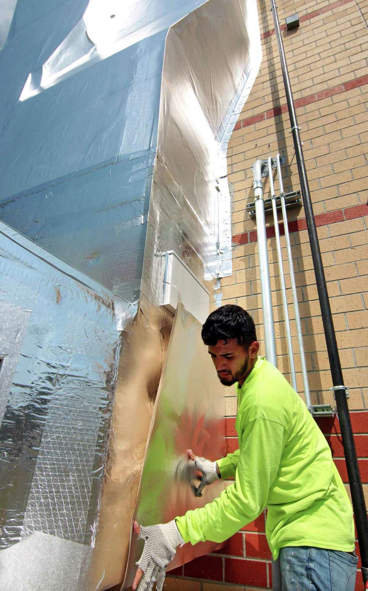 Brian Giraldo from KMK Insulation of North Haven, finishes working on the new DOAS system, or "dedicated outdoor air system," at Westover Elementary School in Stamford, Conn., on Friday August 27, 2021.