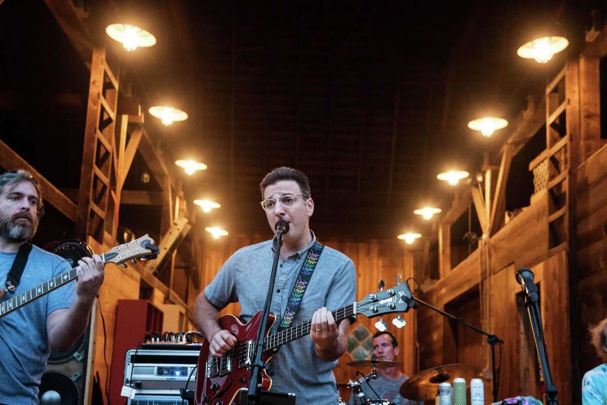 Drew Contessa plays bass for Grateful Dead tribute band, Bear's Choice, at Ambler Farm's Sayonara to Summer concert on Saturday, Aug. 21. Right, Vienna Eriksen and Amelia Ruggiero play Duck, Duck, Goose will concert-goers enjoy dining alfresco. More photos on page A3.