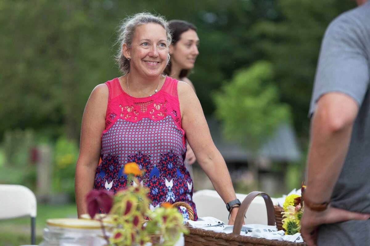 Ambler Farm's Executive Director, Ashley Kineon, greets guests at the farm's Sayonara to Summer concert with Grateful Dead tribute band, Bear's Choice, on Saturday.