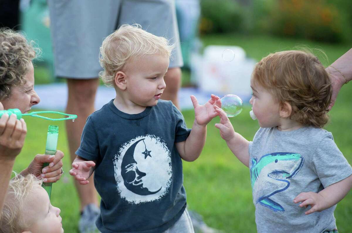 Vincent Mika, 19-months, and James Swanson, 18-months, play with a bubble blown by Lauren Mika at Ambler Farm's Sayonara to Summer concert with Grateful Dead tribute band, Bear's Choice, on Saturday, Aug. 21, 2021, in Wilton; Connecticut.