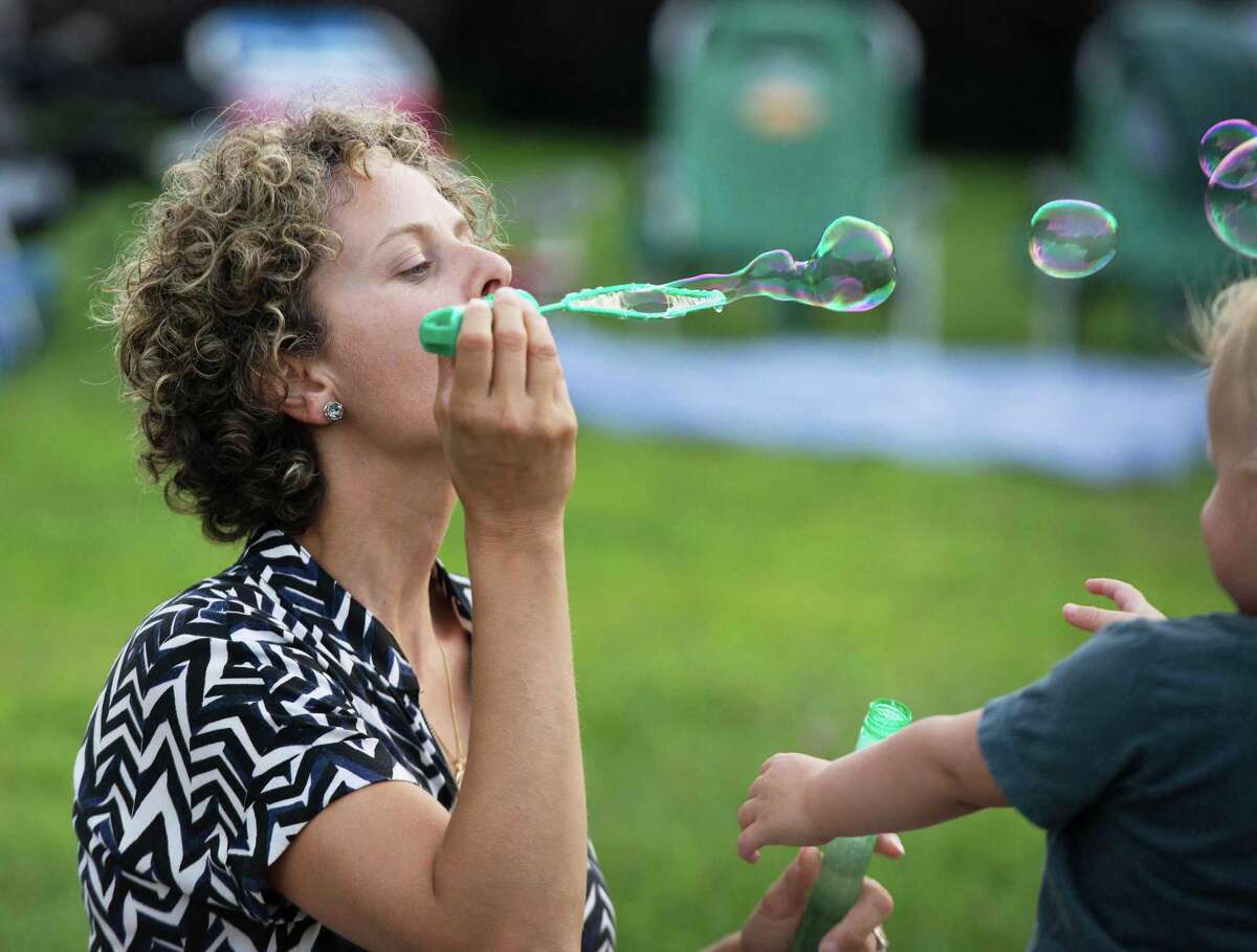 Lauren Mika blows bubbles with Vincent Mika, 19-months, at Ambler Farm's Sayonara to Summer concert with Grateful Dead tribute band, Bear's Choice, on Saturday, Aug. 21, 2021, in Wilton, Connecticut.