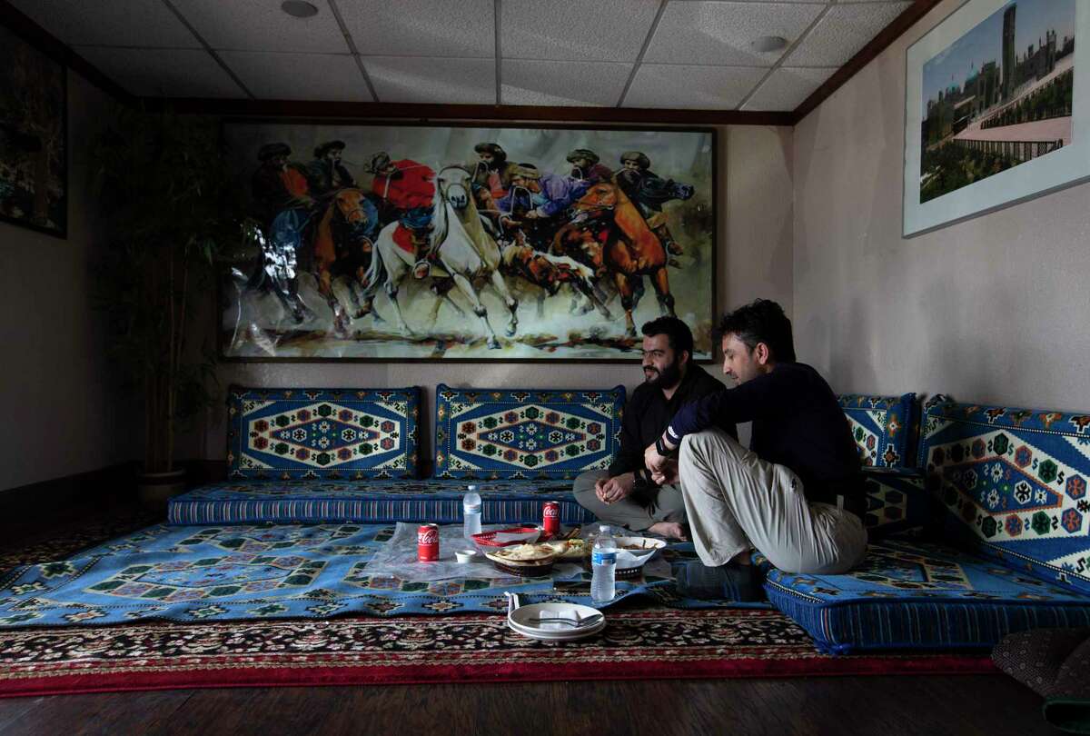 Ezzatullah Hamidi, left, and Dastagir Khan, who both are Afghan Special Immigrant Visa holders, dine at the Afghan Village restaurant on Thursday, Aug. 26, 2021, in Houston. Both men have been living in Austin for a couple of years since coming to the United States. Khan said his wife and children were evacuated from Afghanistan to Qatar several days ago but his daughter fell sick and was in the ICU at a hospital. Therefore, he is trying to apply visa to go to Qatar and see his daughter as soon as he can.