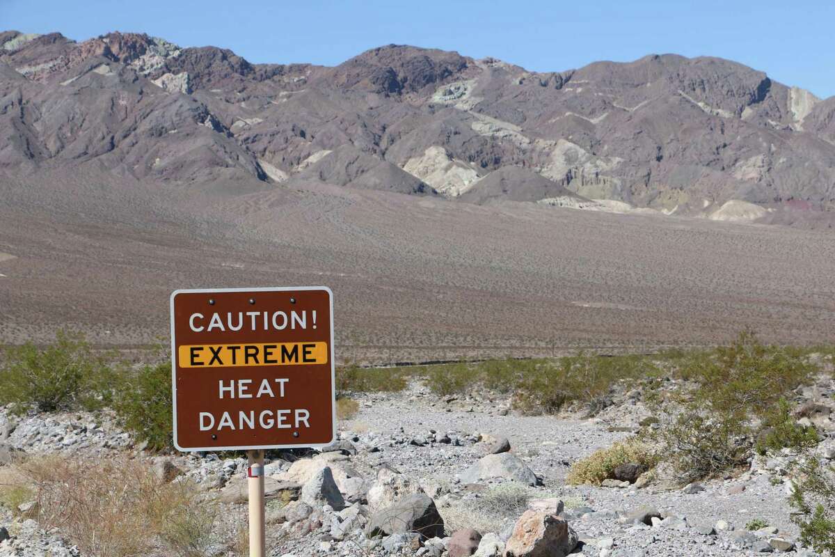 A roadside sign warns visitors as they enter Death Valley National Park about extreme heat.