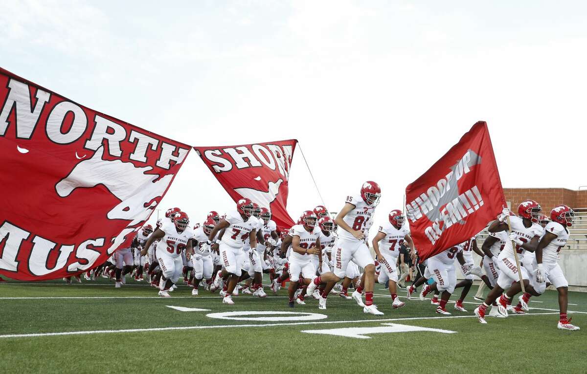 Members of the North Shore football team emerge from the banner before the start of the first half of a high school football game at Freedom Field, Friday, August 27, 2021, in Iowa Colony.