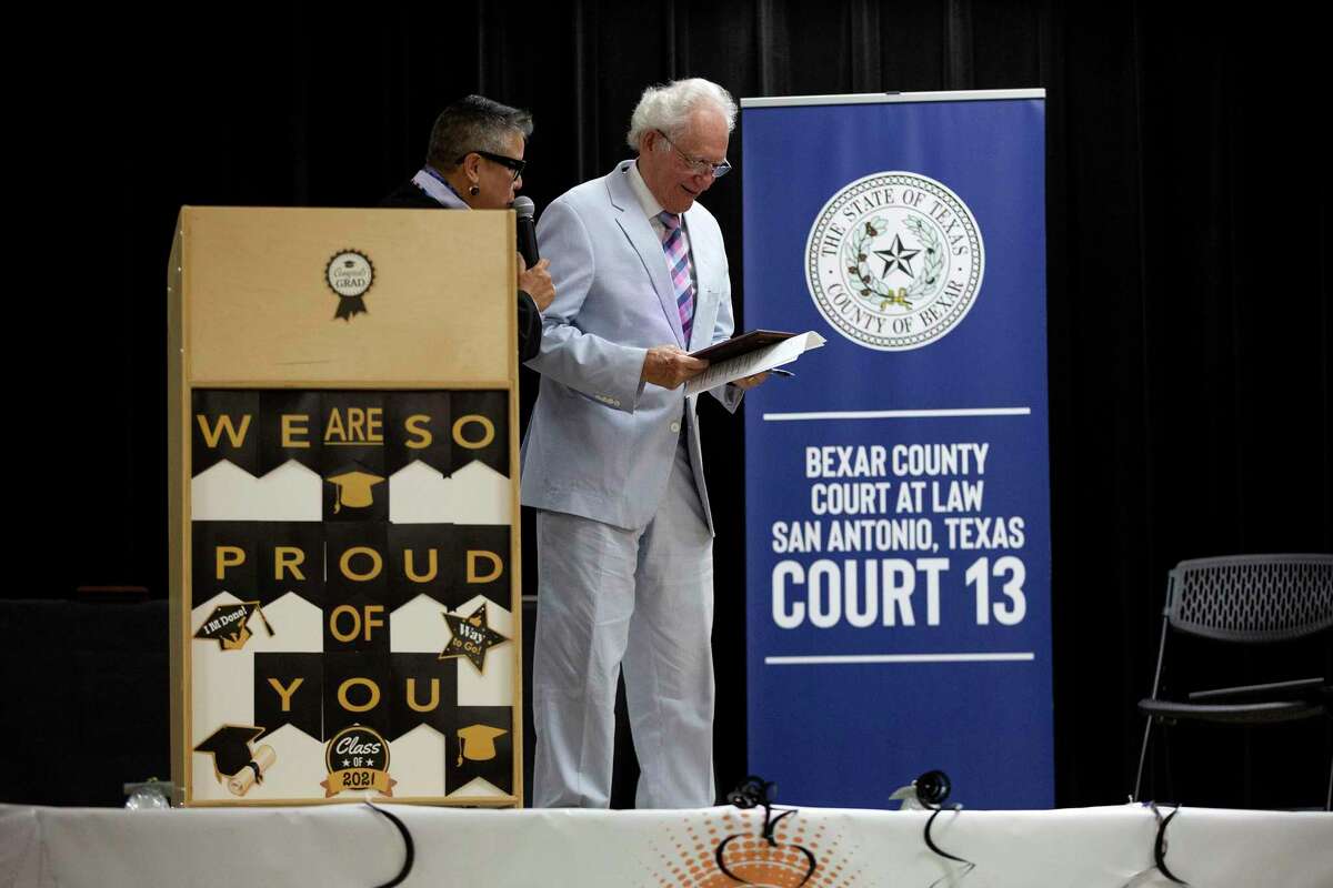 Judge Rosie Speedlin-Gonzalez gives a Semilla award to former county court-at-law judge Al Alonso at the first graduation ceremony of Reflejo Court, a program that helps those charged with misdemeanor domestic violence.