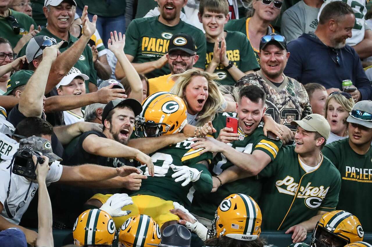 Green Bay Packers running back Aaron Jones (33) leaps into the stands after scoring on a 22-yard touchdown recephoton against the Houston Texans during the second quarter of an NFL pre-season football game Saturday, Aug. 14, 2021, in Green Bay, Wis.