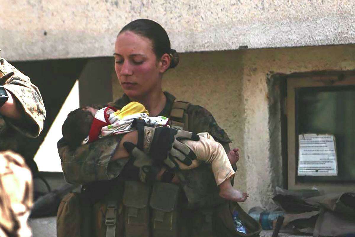 Marine Sgt. Nicole Gee holds a baby at the Kabul airport days before her death in a suicide blast.