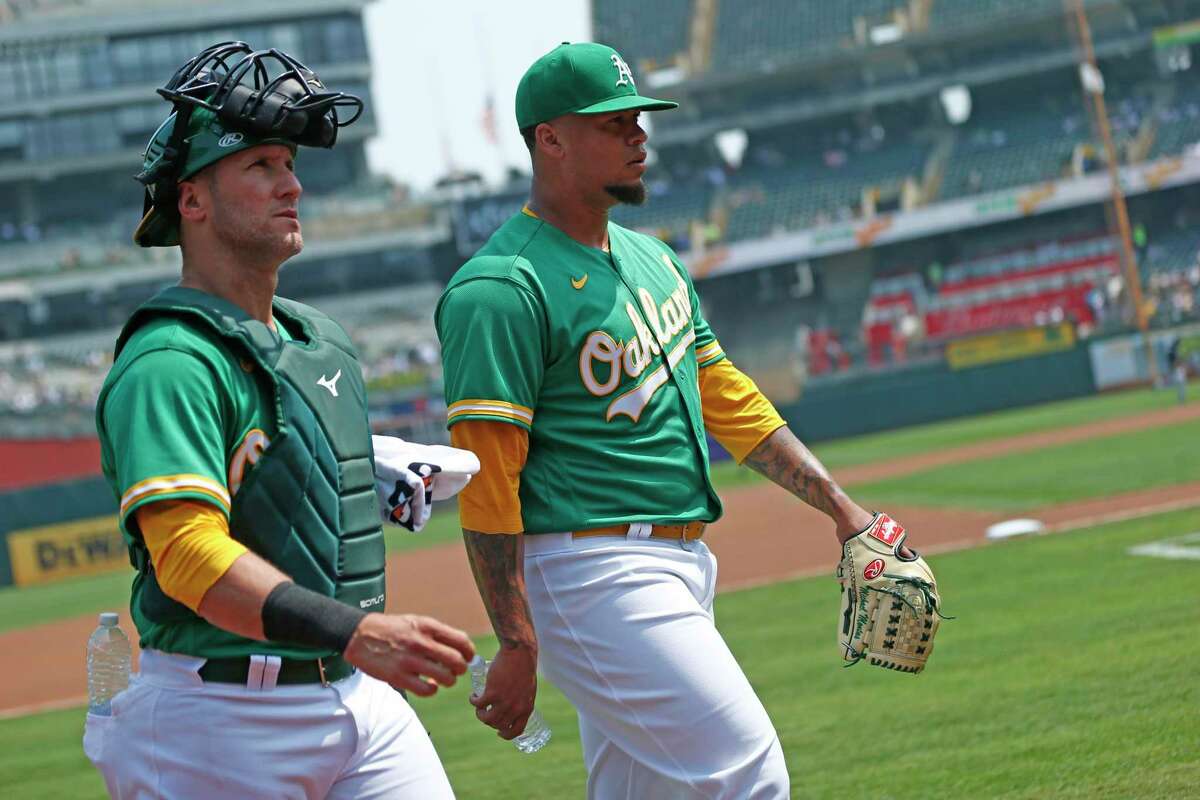 From left: Oakland Athletics catcher Yan Gomes (23) and A’s starting pitcher Frankie Montas (47) after warming up before the MLB game against the New York Yankees at RingCentral Coliseum on Saturday, Aug. 28, 2021, in Oakland, Calif.