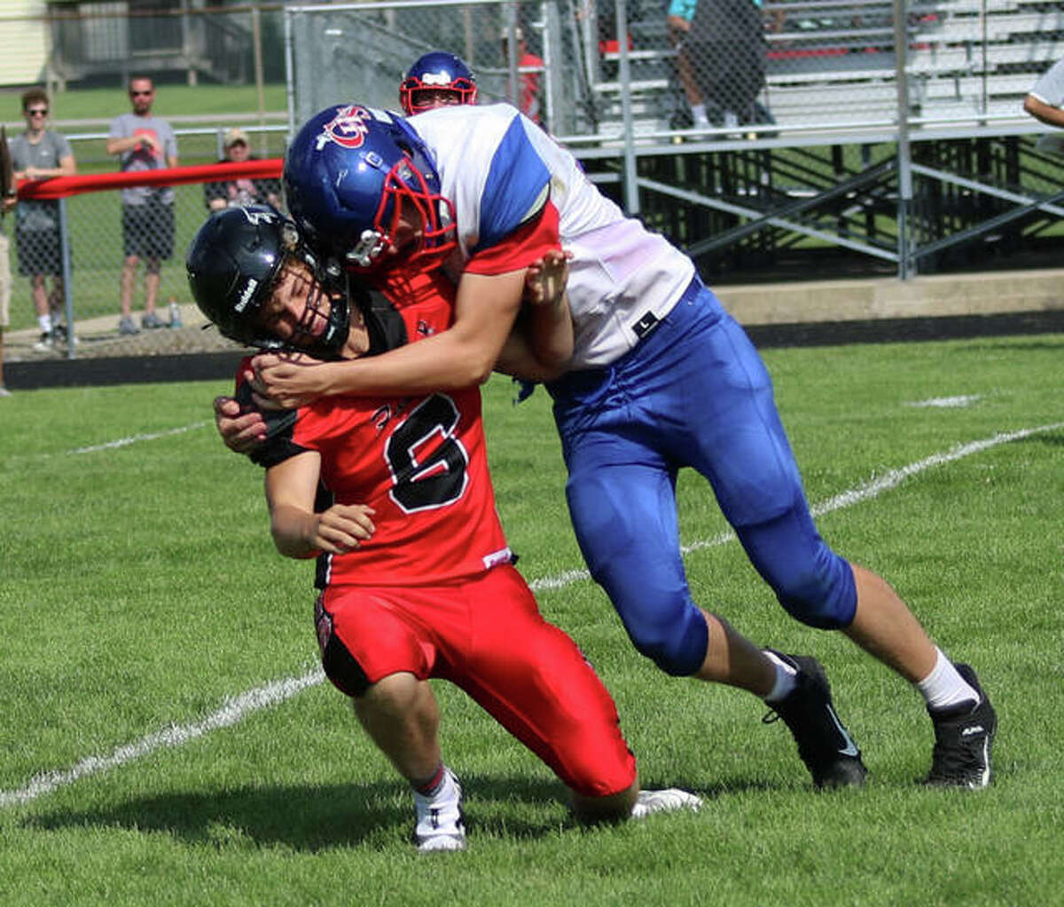 Carlinville’s Aaron Wills delivers a hit to Gibson City QB Kellen Deschepper (6), who just got off a pass under pressure on Saturday in Gibson City.