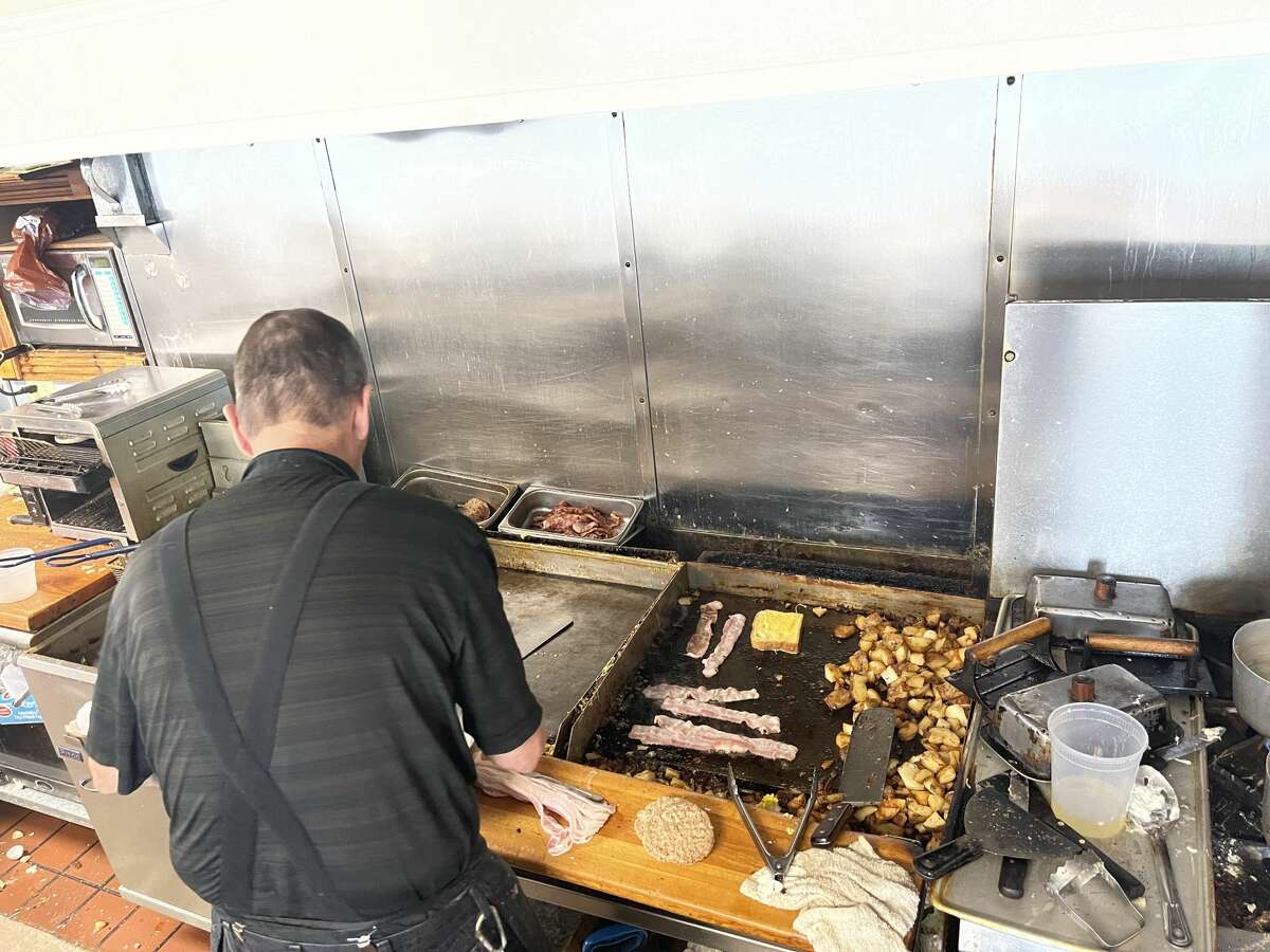 Warren Bush works the grill at Oliver's Cafe on Aug. 29, 2021.