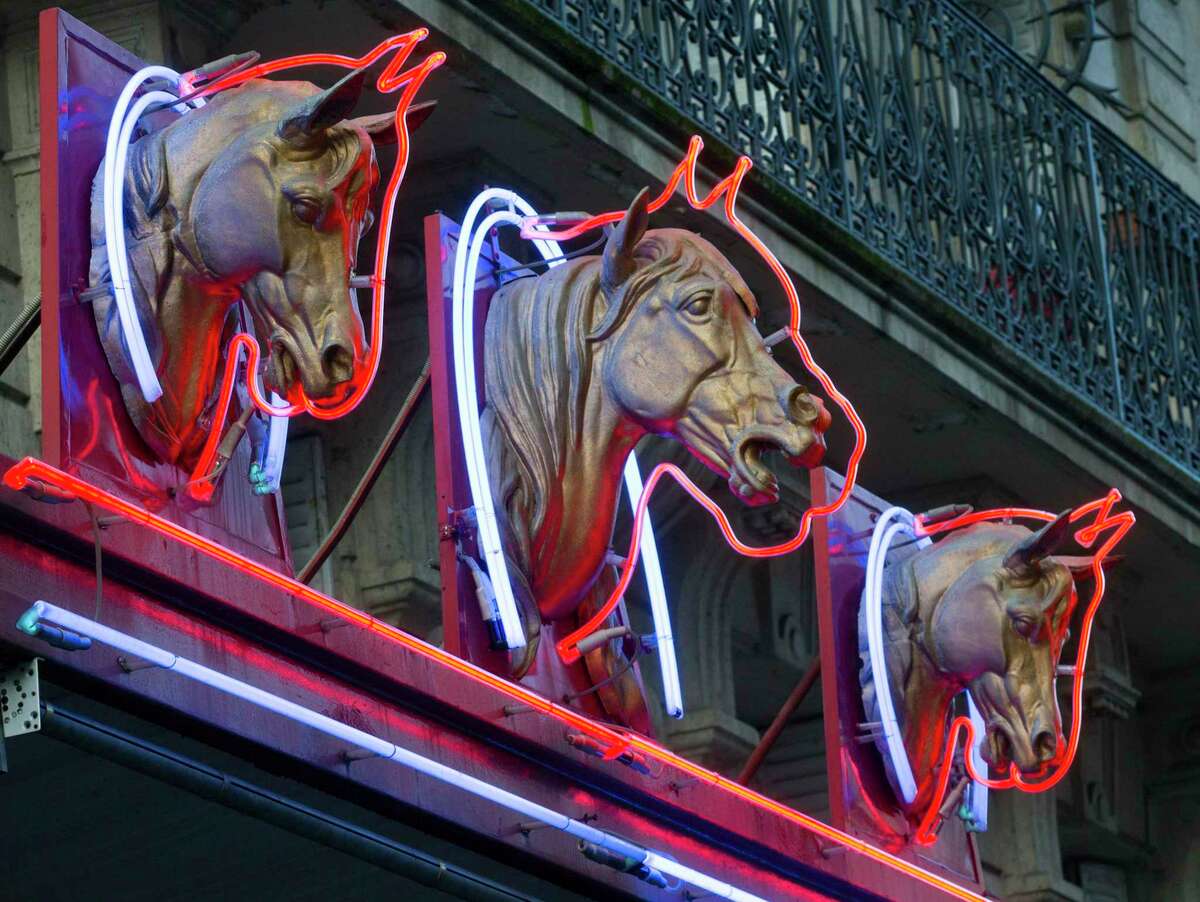 Three horse-head statues advertise a horsemeat butcher shop in Paris. Many countries condemn eating horses.