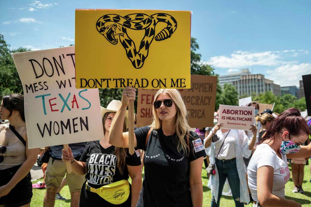In this photo from May 29, 2021, protesters hold up signs at a protest outside the Texas state capitol in Austin, Texas.