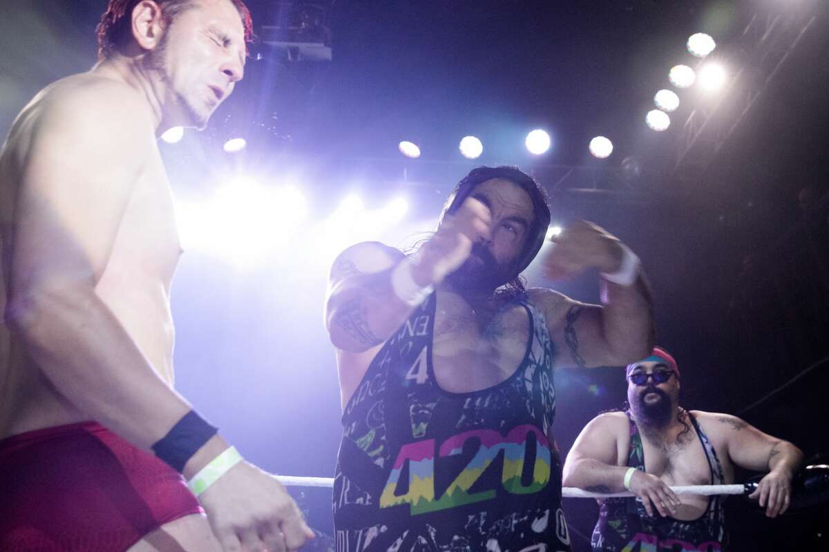 Rick Scott, center, of the legendary tag team duo the Stoner Brothers, hits Joe DeSoul as Scott Rick looks on at the Hoodslam underground pro wrestling show at the DNA Lounge in San Francisco on Aug. 22, 2021.