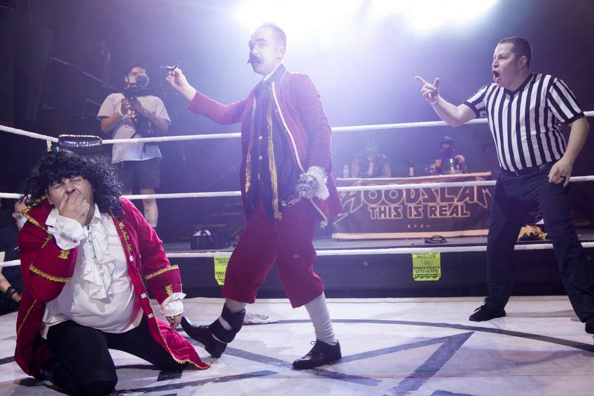 Wrestler Captain Hook, center, pulls off the mustache off Cap'n Morgan while Referee Wiggles looks on during a Hoodslam match at DNA Lounge in San Francisco on Aug. 22, 2021.