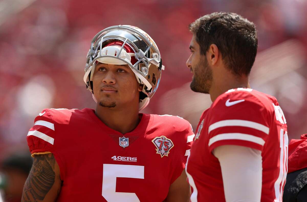 Jimmy Garoppolo and Trey Lance of the San Francisco 49ers talk to each other on the sidelines before their preseason game against the Las Vegas Raiders at Levi's Stadium on Aug. 29, 2021, in Santa Clara, Calif.