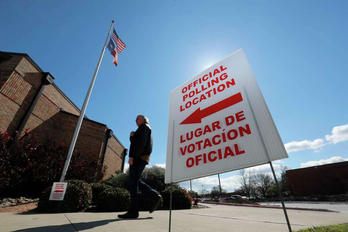 Using both the English and Spanish language, a sign points potential voters to an official polling location during early voting in Dallas, Wednesday, Feb. 26, 2020. Early primary voting in Texas is continuing with a strong turnout ahead of Super Tuesday. (AP Photo/LM Otero)