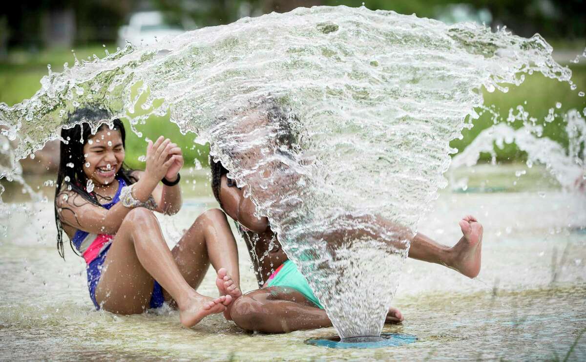 Emma Cordoba, 7, left, and Dallas Castillo, 6, play in the splash pad at Montie Beach Park Wednesday, July 21, 2021 in Houston. 