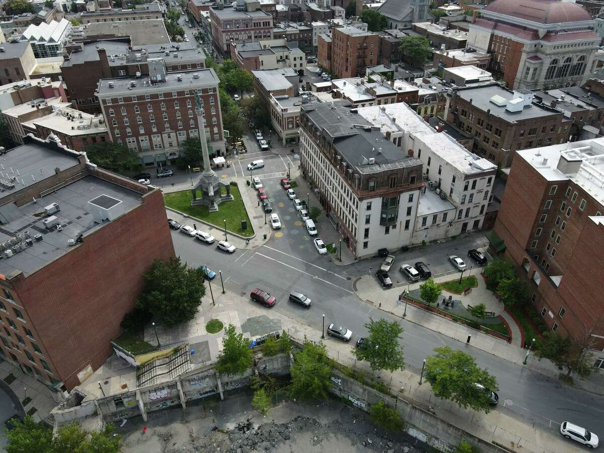 Monument Square and the empty lot where City Hall once stood, bottom, on Monday, Aug. 30, 2021, in Troy, N.Y. A public meeting is planned for Sept. 9 on proposals for development of the site.