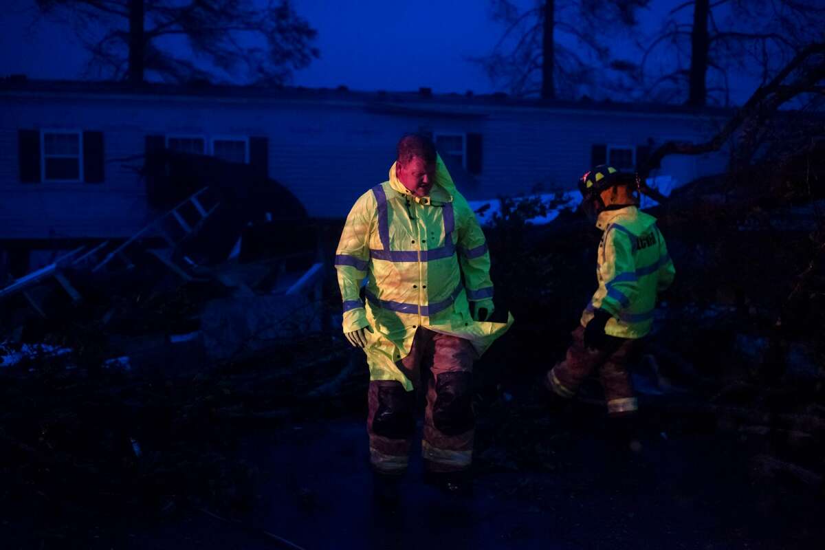 Firefighters cut through trees on the road in Bourg, Louisiana as Hurricane Ida passes on Aug. 29, 2021. (Photo by Mark Felix/AFP via Getty Images)