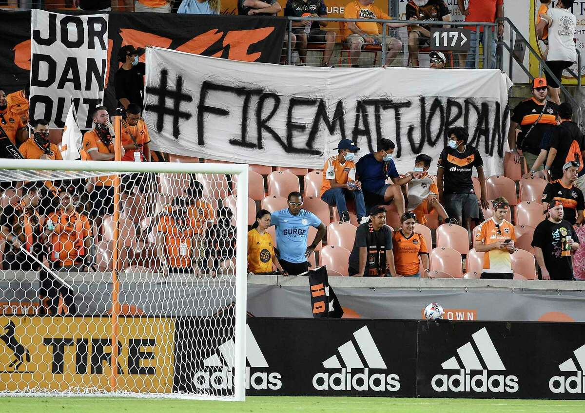 Fans hold signs calling for the firing go Houston Dynamo General Manager Matt Jordan during the second half of an MLS soccer matchv against FC Dallas, Saturday, Aug. 21, 2021, in Houston.