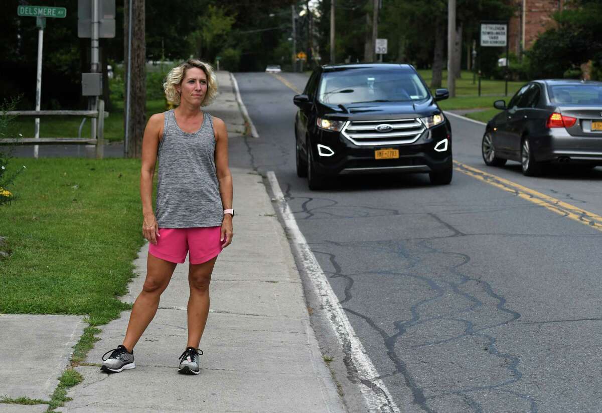 Jen Hebner stands on the sidewalk on Kenwood Avenue where she was hit in the back of the head by a truck's door mirror while running last week on Monday, Aug. 30, 2021, in Delmar, N.Y. She is urging the town to put in temporary safety measures outside nearby Bethlehem Middle School.