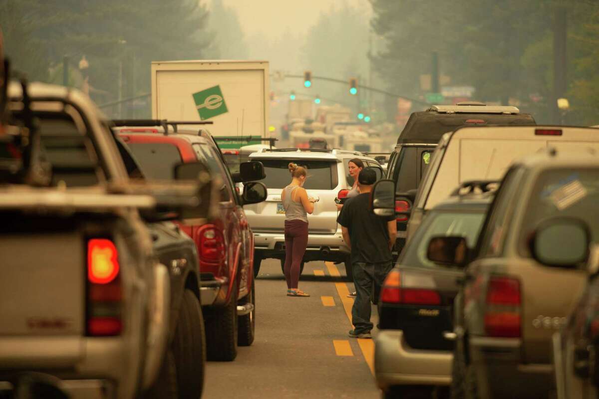 South Lake Tahoe residents mill around their vehicles while they are all stuck in eastbound evacuation traffic on Highway 50 after mandatory evacuation orders were issued to all of South Lake Tahoe, Calif. due to the approaching Caldor Fire.