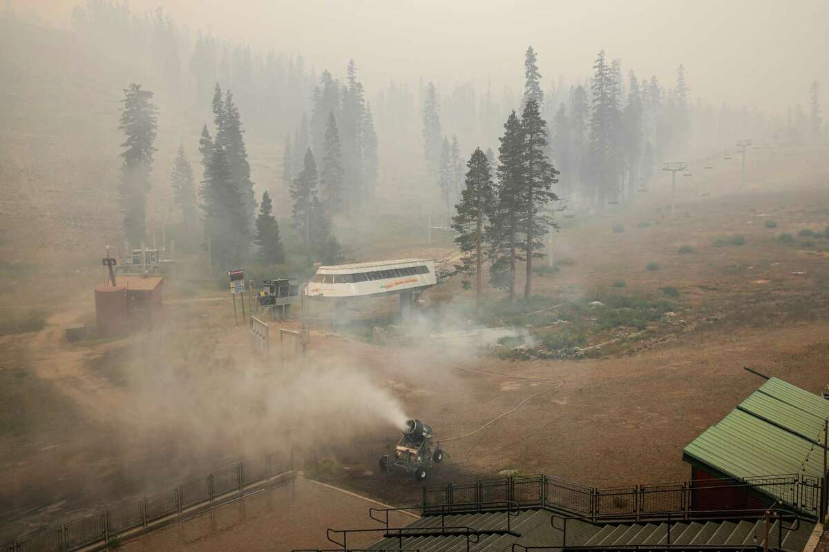 A snow maker drenches a slope-facing patio in efforts to protect it from the Caldor Fire at Sierra-at-Tahoe ski resort.