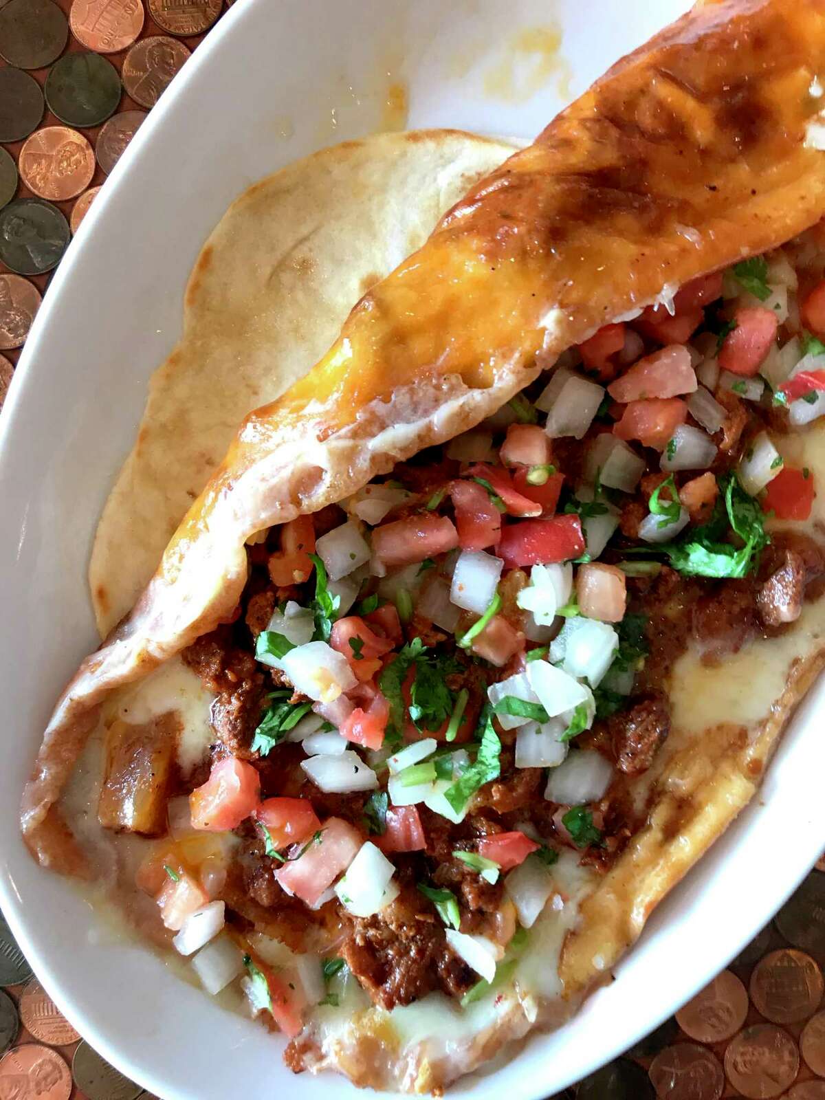 The costra taco at Chela's Tacos is an indulgent dish that starts with a giant platter of cheese griddled to a crisp.