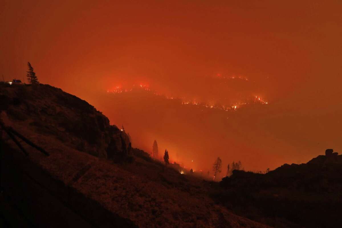 Christmas Valley in the town of Meyers, is seen awash in the glow of flames and smoke as the Caldor Fire encroaches on the community in Meyers, Calif., on Monday.