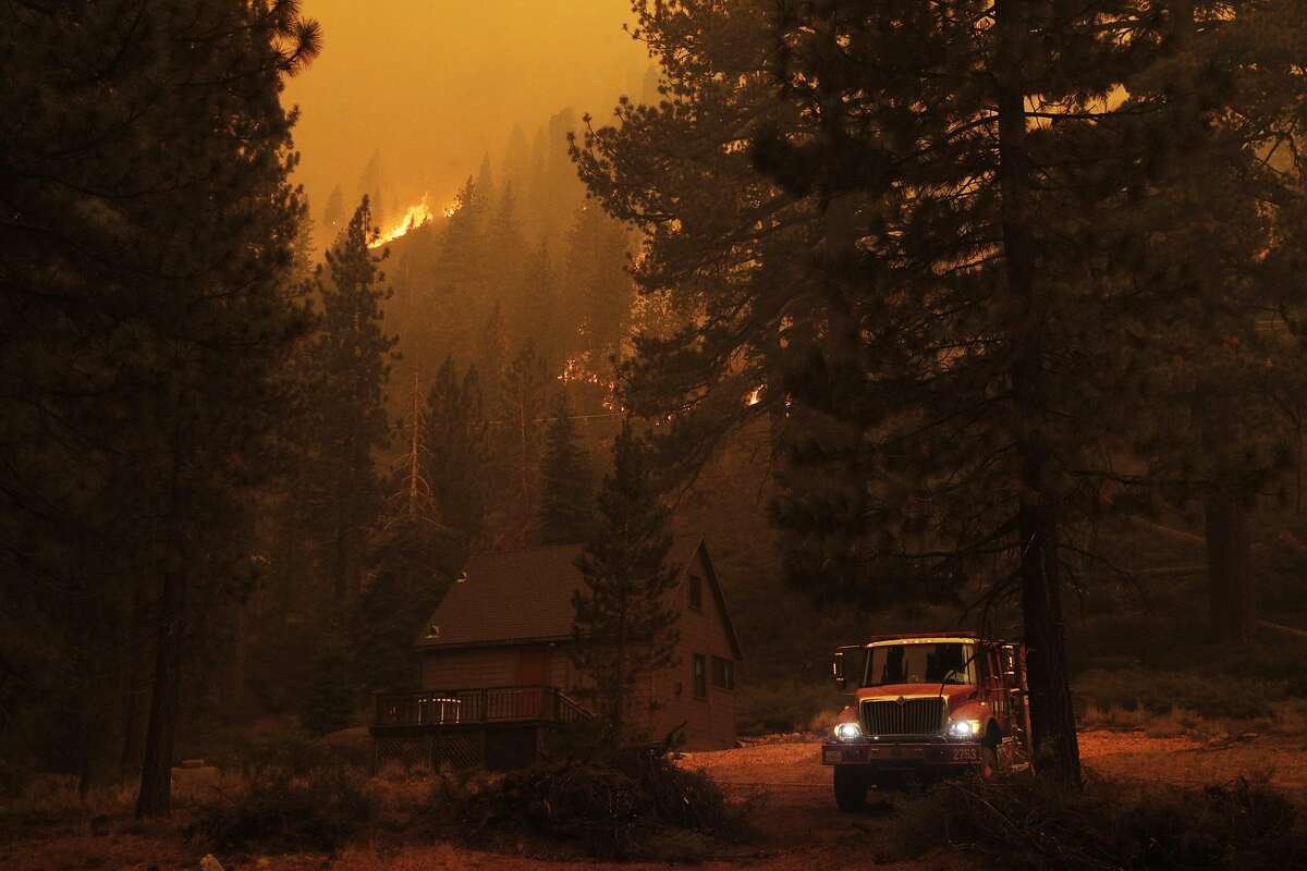Firefighters working structure protection in Christmas Valley in the town of Meyers work to prevent further devastation left by the Caldor Fire in Meyers, Calif., on Monday, August 30, 2021.