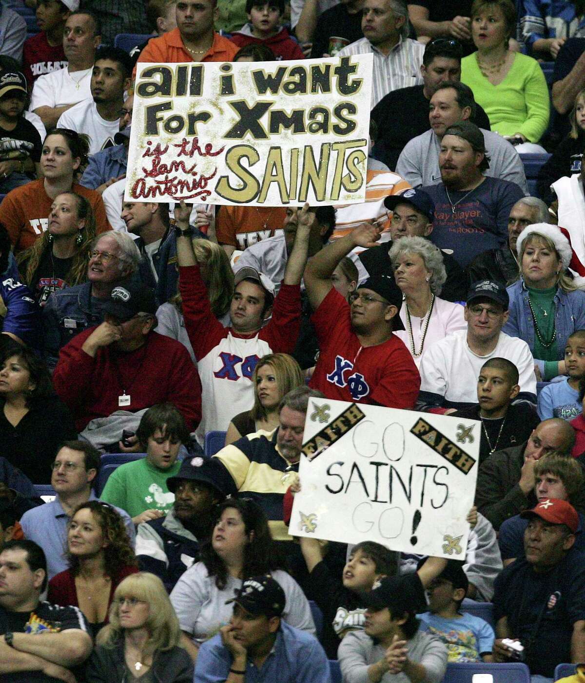 Signs held by fans express the desire to have a professional football team in San Antonio during the Saints-Detroit Lions game at the Alamodome on Saturday, December 24, 2005. (Kin Man Hui/staff)