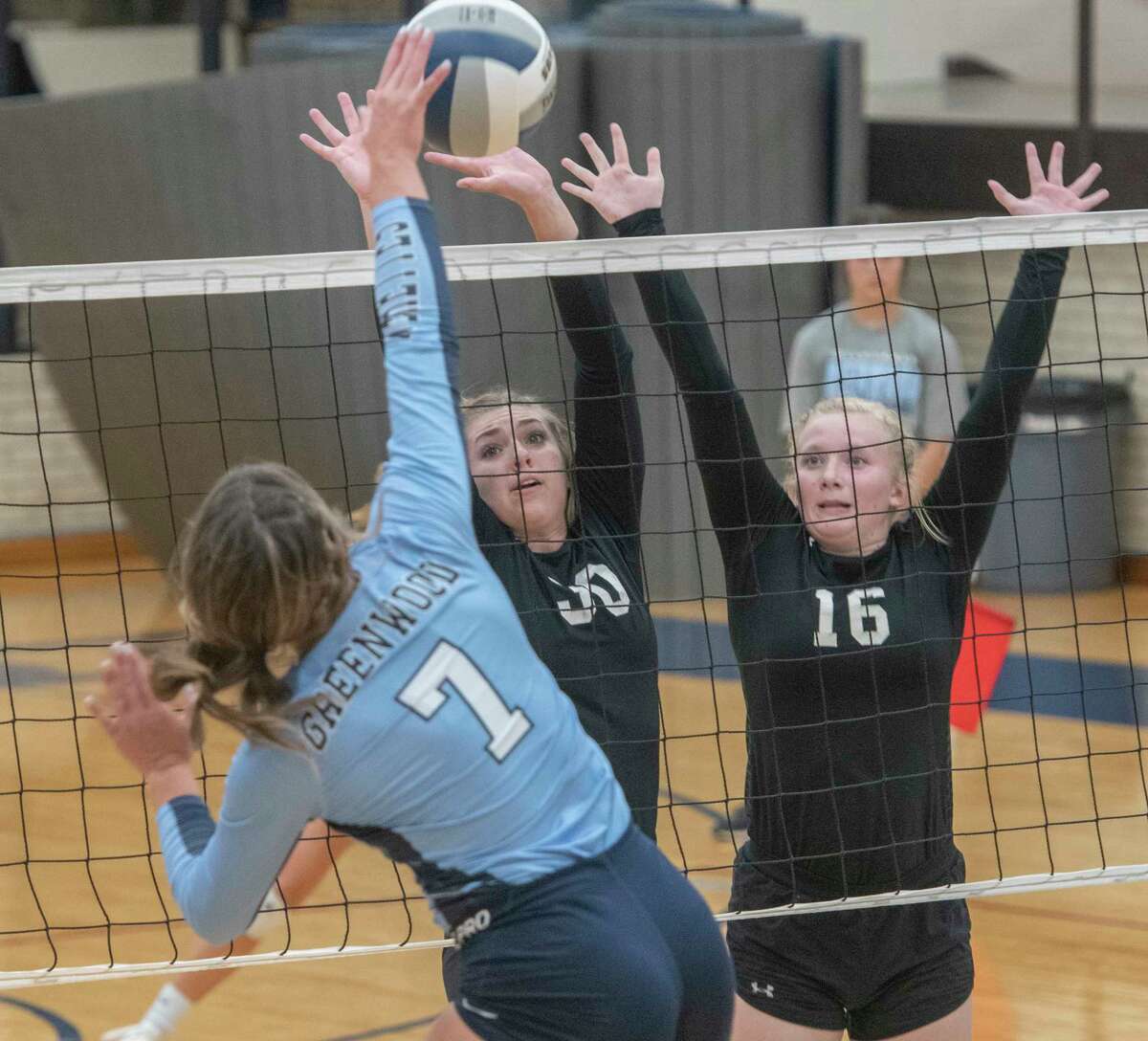 Greenwood's Kirklyn Smith looks for a hit as Midland Classical's Elise Grigsby and Kenedi Carter try to block 08/31/2021 at Greenwood High School. Tim Fischer/Reporter-Telegram