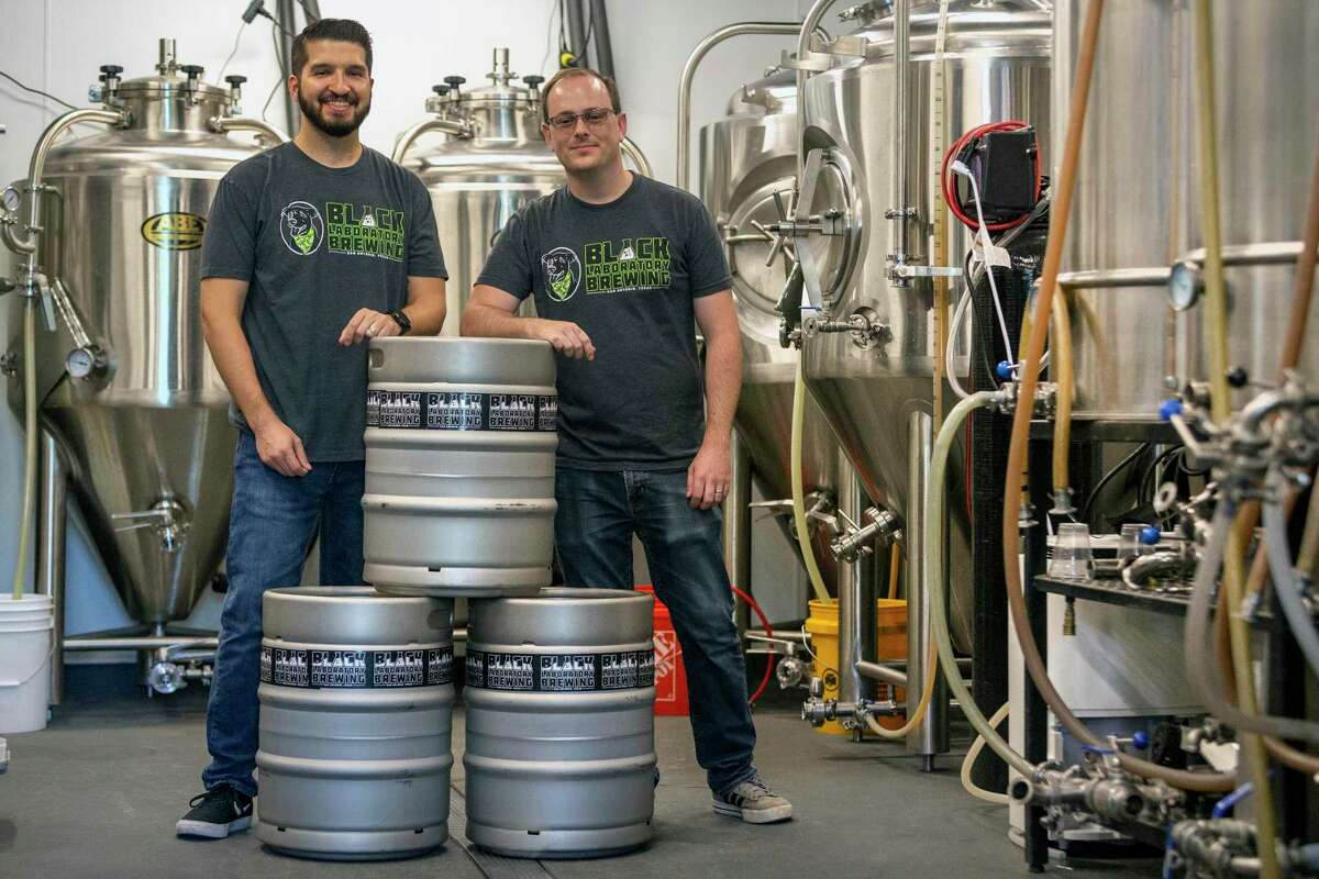 Black Laboratory Brewing company owners Tim Castaneda, left, and Jeff Weihe pose in the company's brewing room at the company's taproom at the intersection of North Hackberry and East Houston Street.