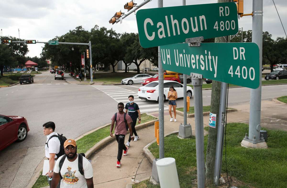 A man looks up at a sign for Calhoun Road where it intersects University Drive on Tuesday, Aug. 31, 2021, on the University of Houston campus in Houston. Houston City Council will vote tomorrow to rename part of Calhoun Road to Martin Luther King Boulevard.