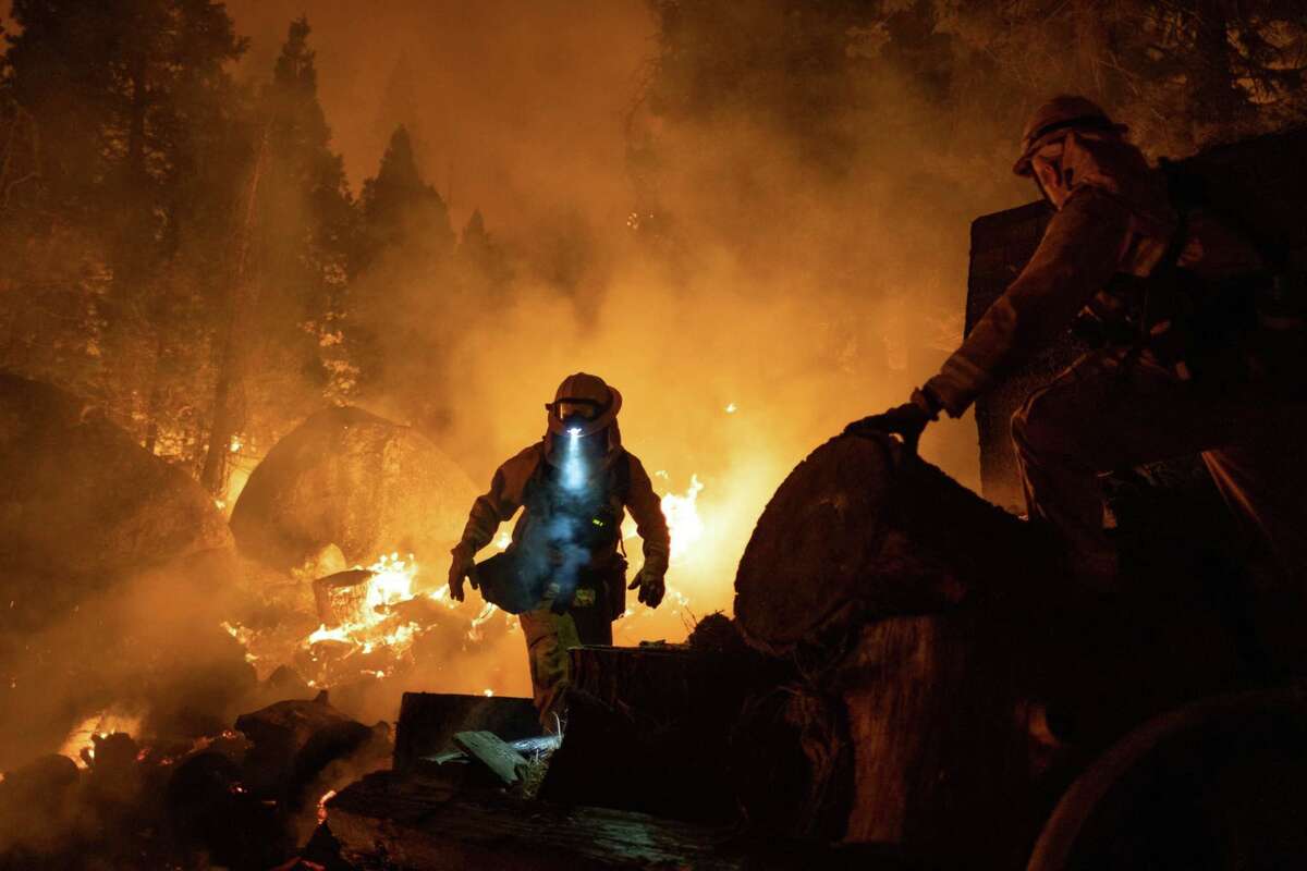 Firefighters attempt to protect a home near Santa Claus Drive during the Caldor Fire near Meyers, Calif., on Aug. 31, 2021.