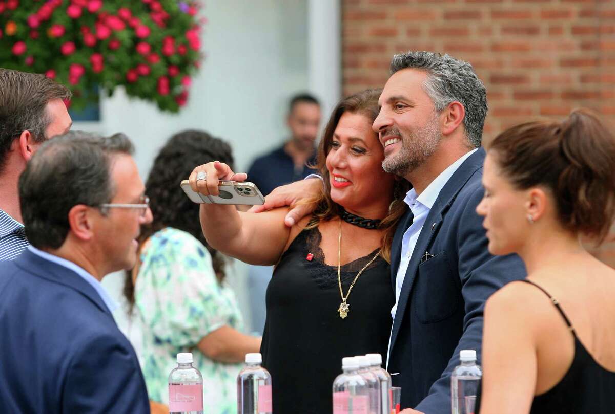 Mauricio Umansky, Founder and CEO of The Agency, poses for photos with Nurit Coombe, from the Washington D.C. office, during the grand opening celebration of it's newest location in New Canaan, Conn., on Tuesday August 31, 2021.