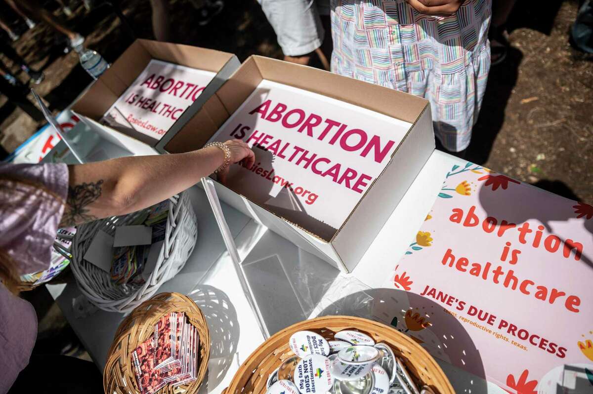 Attendees grab signs at a protest outside the Texas Capitol in May. Thousands of protesters emerged in Austin in response to a new bill that would outlaw abortions after a fetal heartbeat is detected. The bill was signed on Wednesday by Gov. Greg Abbott. (Sergio Flores/Getty Images/TNS)