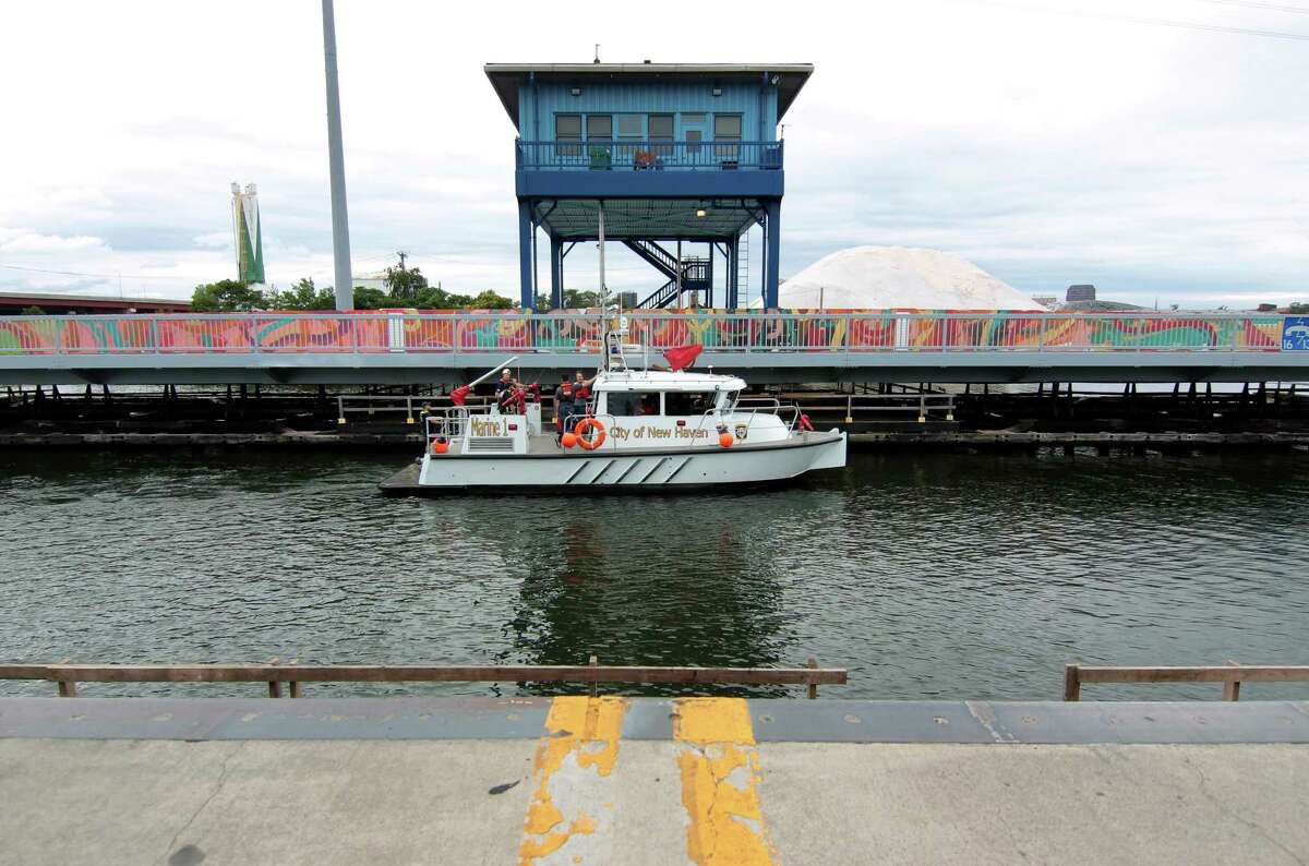 The New Haven Fire Department drops off a crew to diagnose the swing bridge on Chapel Street which malfunctioned and stuck in the open position in New Haven, Conn., on Saturday August 28, 2021.