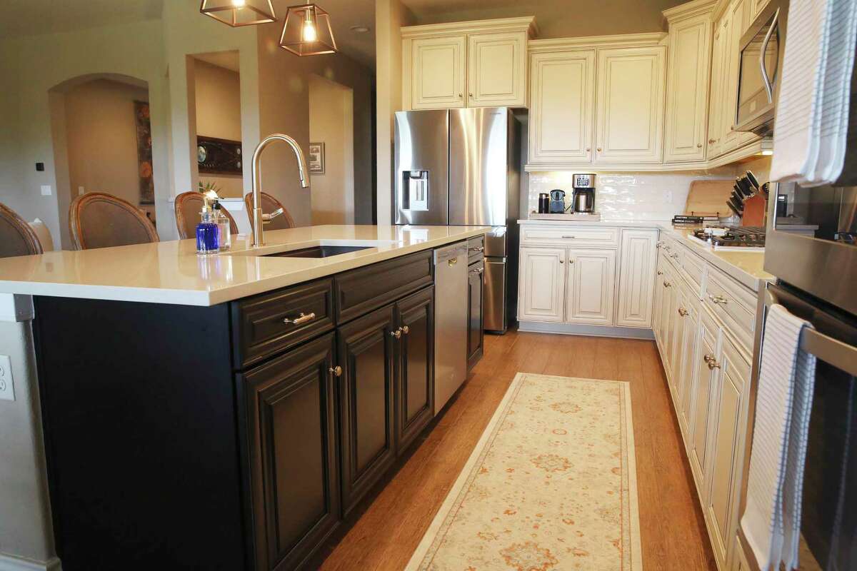 The island cabinets were painted black to contrast with the facing cream-colored cabinets.
