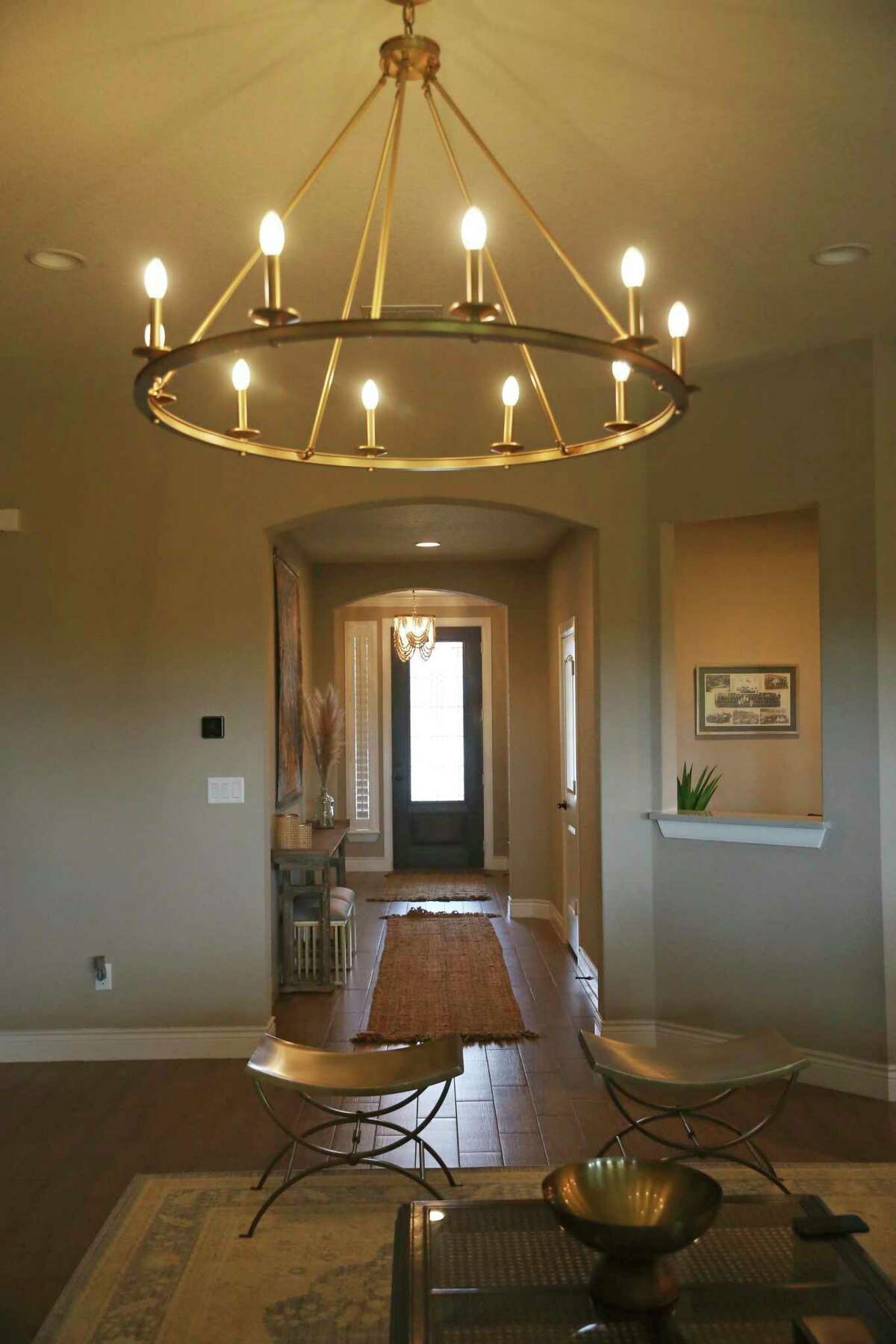 A large circular chandelier with electric candles hangs above the living room seating area.