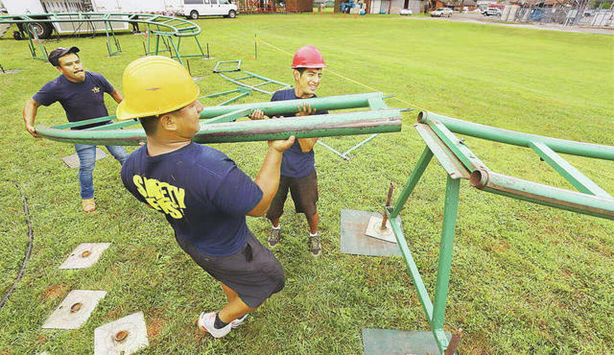 Employees of Luehrs’ Ideal Rides on Tuesday lift another section of the tracks for the Jungle Twist roller coaster into place during set-up in Bethalto Park for the annual Bethalto Homecoming. The event was canceled last year because of COVID-19 and carnival managers said the company did almost no business in 2020. The Bethalto Homecoming, always held over the Labor Day weekend, is traditionally one of the largest events in Madison County featuing rides, food, vendors and entertainment. The event runs Friday evening through Monday evening. - John Badman|The Telegraph