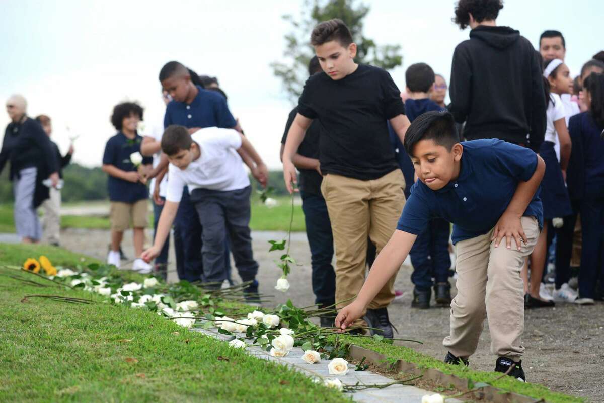 Andres Lopez , 5th grader at Geraldine W. Johnson School in Bridgeporl, lays a rose at the memorial during the State of Connecticut's 18th annual 9/11 Memorial Ceremony honoring and celebrating the lives of those killed in the September 11, 2001 terrorist attacks Thursday, September 5, 2019, at Sherwood Island State Park in Westport, Conn. Family members of those who were killed in the attacks participated, and the names of the 161 victims with ties to Connecticut were read aloud.