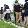 Andres Lopez , 5th grader at Geraldine W. Johnson School in Bridgeporl, lays a rose at the memorial during the State of Connecticut's 18th annual 9/11 Memorial Ceremony honoring and celebrating the lives of those killed in the September 11, 2001 terrorist attacks Thursday, September 5, 2019, at Sherwood Island State Park in Westport, Conn. Family members of those who were killed in the attacks participated, and the names of the 161 victims with ties to Connecticut were read aloud.