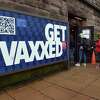 Yale University students line up outside of Durfee's Sweet Shoppe on Elm Street in New Haven on September 1, 2021 next to a sign encouraging COVID-19 vaccinations.