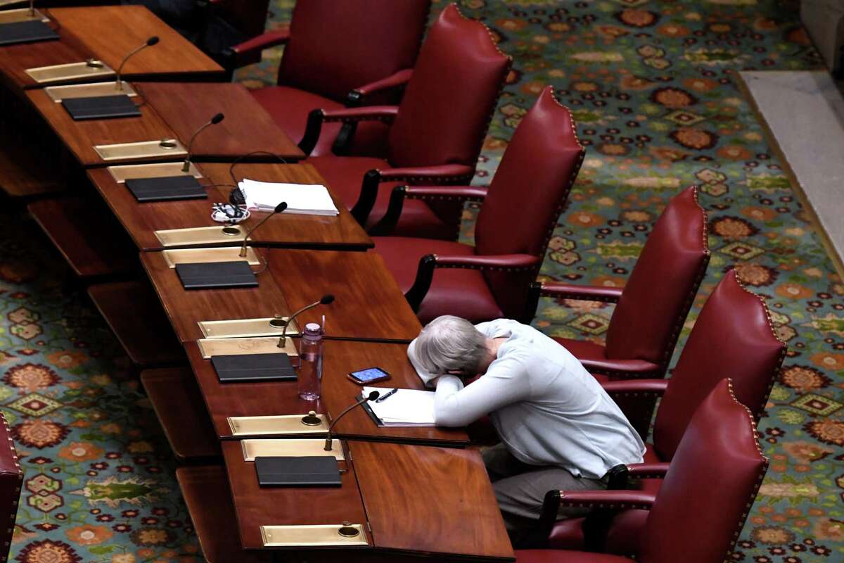 State Sen. Rachel May, (D) 53rd, takes a brief rest on her Senate Chamber desk before the start of a special session on Wednesday Sept. 1, 2021, at the Capitol in Albany, N.Y.